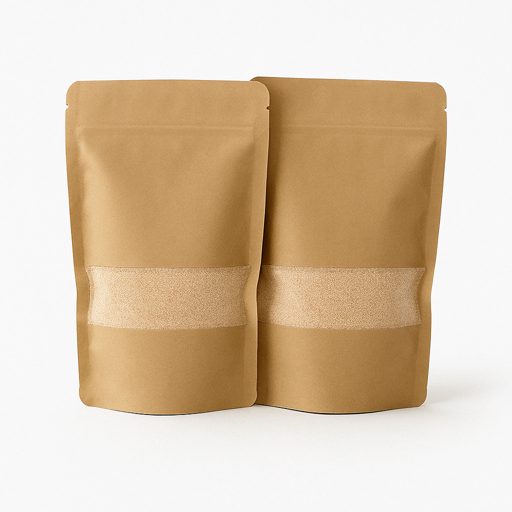 Twee kraft papieren zakken met transparant venster gevuld met beige kaarsenzand, gepresenteerd op een strakke, lichtgrijze ondergrond. Dit product is beschikbaar in vijf kleuren: wit, zwart, grijs, beige en roze.